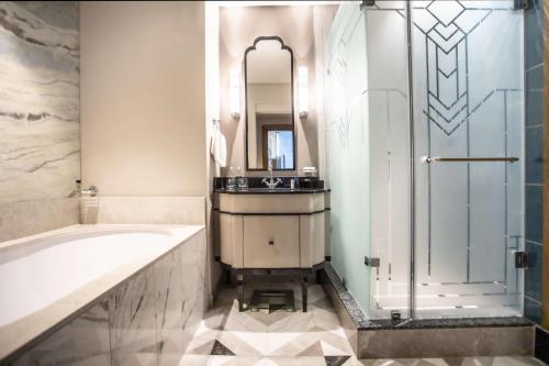 德班Suncoast Hotel & Towers的带浴缸、水槽和淋浴的浴室
