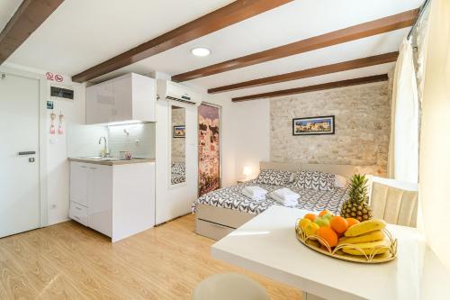 斯普利特Sv.Duje Apartments的厨房以及带床和桌子的客厅。