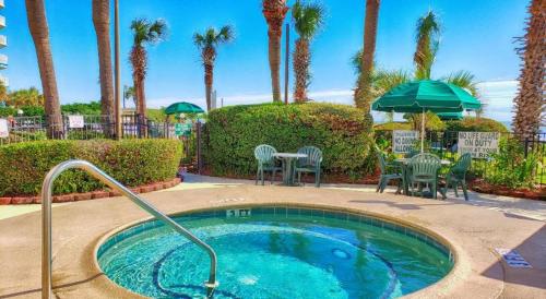 默特尔比奇Ocean Front 53 Steps的一个带桌椅的小游泳池,棕榈树