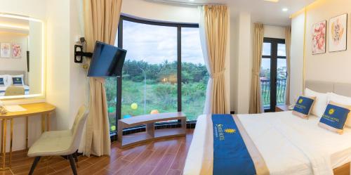 Bạc LiêuSUNRISE Hotel Bạc Liêu的一间卧室设有一张床、一台电视和一个窗口。