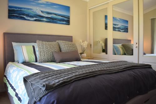 St Georges BasinDiscover St Georges Basin的一间卧室配有一张带枕头的大床