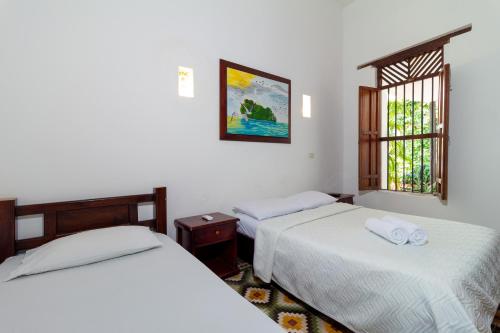 卡塔赫纳Casa Pedro Romero的一间卧室设有两张床和窗户。