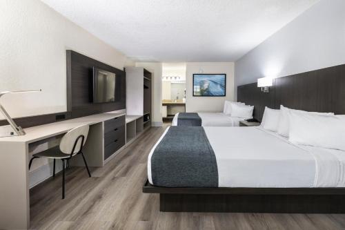奥兰多Avanti International Resort的酒店客房配有两张床和一张书桌