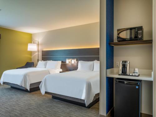 沃特敦Holiday Inn Express & Suites - Watertown, an IHG Hotel的一间酒店客房,设有两张床和电视