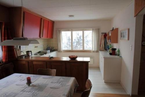 莱克斯Chalet Mon Refuge的一间厨房,里面装有红色橱柜和一张桌子