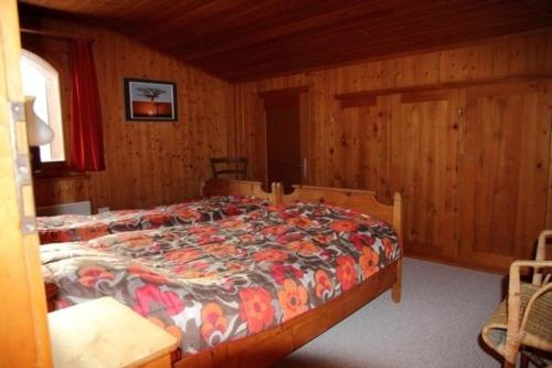 莱克斯Chalet Mon Refuge的木制客房内的一间卧室,配有一张床