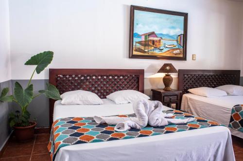 卡里略Hotel Hacienda del Mar的酒店客房,配有两张带毛巾的床