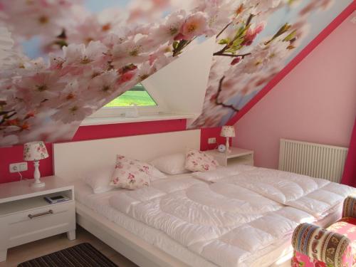 RakowHaus Dornröschen的一间卧室配有一张天花板上花卉绘画的床。