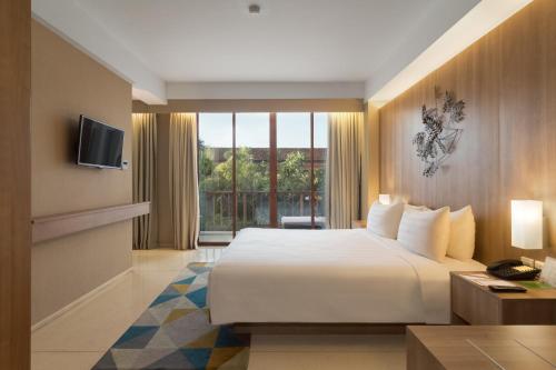 库塔巴厘库塔格兰德祖丽酒店的酒店客房设有一张床和一个大窗户