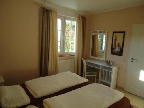 罗威Charmantes Appartement in Rowy mit Grill, Garten und Terrasse的酒店客房设有两张床、一张桌子和一面镜子