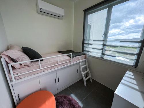 瓜埠Ins2 Langkawi Apartment Kuah的一间小卧室,配有双层床和窗户
