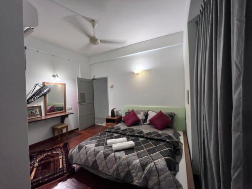 瓜埠RUMAH SINGGAH APARTMENT的一间卧室配有一张带红色枕头的大床