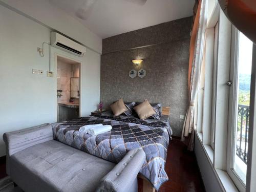 瓜埠RUMAH SINGGAH APARTMENT的卧室配有一张床铺,靠窗边设有长凳