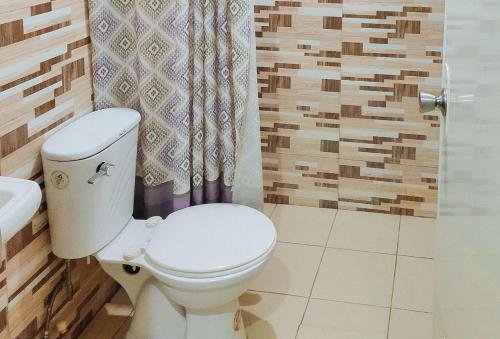 BanhiganIrah's Guest House的浴室配有卫生间、盥洗盆和淋浴。