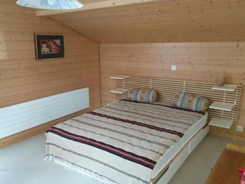 弗鲁蒂根Ferienwohnung Mänimatte的木制客房内的一间卧室配有一张大床