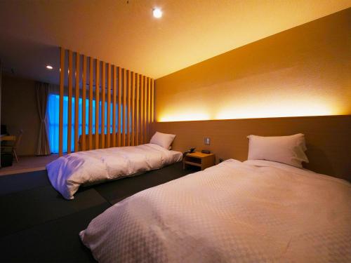 壹岐市斯特拉考特太卡库壹岐酒店的一间卧室设有两张床和窗户。
