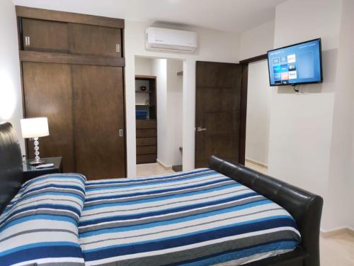 马萨特兰Brujas Tower Beach Resort的一间卧室配有一张床和一台平面电视