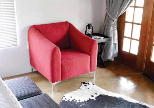 哈博罗内Waterside Cottages的客厅配有红色椅子和桌子