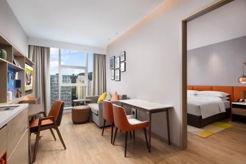 重庆重庆渝北希尔顿惠庭酒店的酒店客房带一张床、一张桌子和椅子