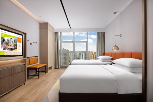 重庆重庆渝北希尔顿惠庭酒店的酒店客房设有两张床和一台平面电视。
