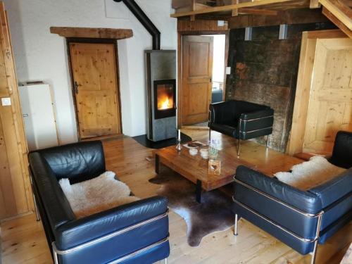 波斯基亚沃Sunny, rustical 5 room cottage in Valposchiavo的客厅配有桌子和壁炉