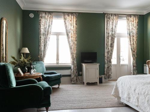 马斯特兰德马斯特兰格兰德酒店的一间卧室设有绿色的墙壁、一张床和一张沙发