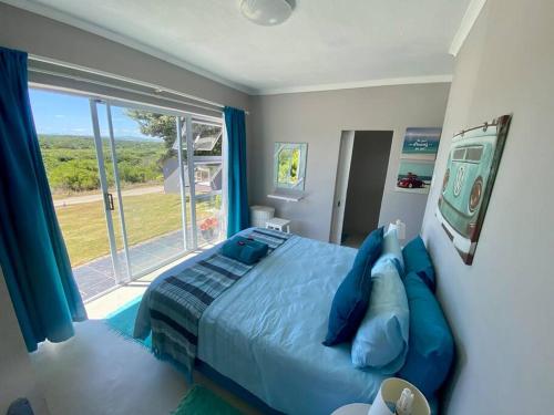 杰弗里湾Grys Patrys - 4 Beds Beach Home的一间卧室设有蓝色的床和大窗户