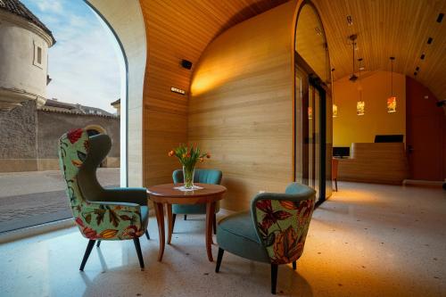 博尔扎诺La Briosa的一间设有两把椅子、一张桌子和一面镜子的房间