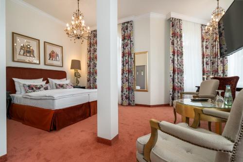 施特雷利茨Hotel Villa am Stadthafen的卧室配有一张床和一张桌子及椅子