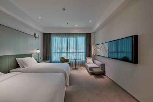 昆明昆明世纪金源大饭店的酒店客房设有两张床和一台平面电视。