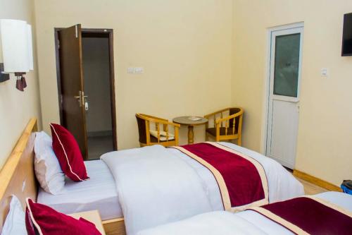 ButwālAmarapali Cottage and Restaurant Pvt. Ltd的一间设有两张红色和白色床单的房间