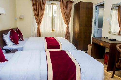ButwālAmarapali Cottage and Restaurant Pvt. Ltd的酒店客房配有两张床和一张书桌