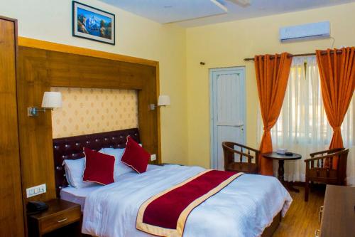ButwālAmarapali Cottage and Restaurant Pvt. Ltd的一间卧室配有一张带红色枕头的大床