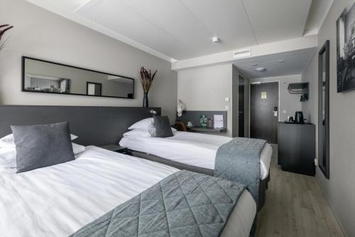 海门林纳原创索克斯酒店瓦库娜花门琳娜的酒店客房,设有两张床和镜子