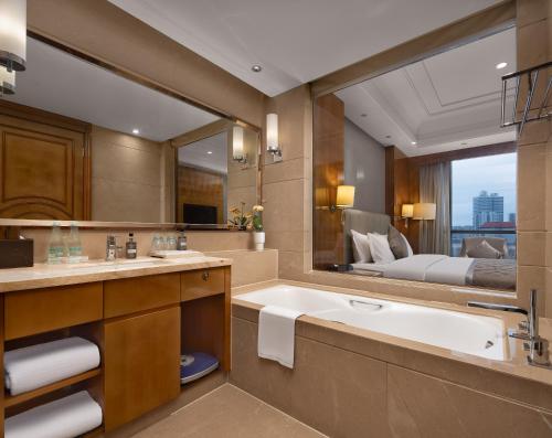 长沙湖南佳兴世尊酒店的一间带浴缸和大镜子的浴室