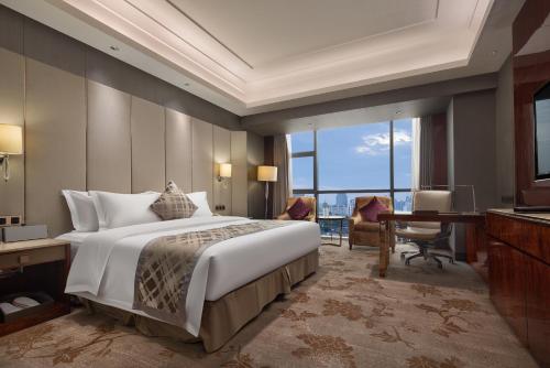长沙湖南佳兴世尊酒店的一间卧室配有一张大床、一张桌子和一台电脑