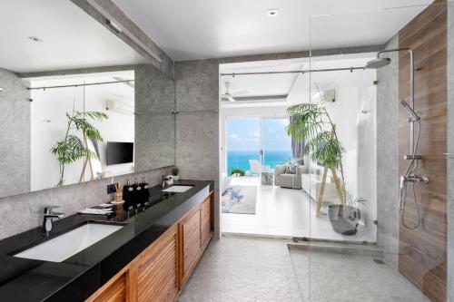 茶云莱海滩梅洛别墅的一间带两个水槽和玻璃淋浴间的浴室