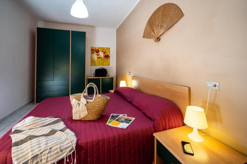 锡尔维玛丽娜Vistamare的一间卧室配有一张带红色毯子和灯的床
