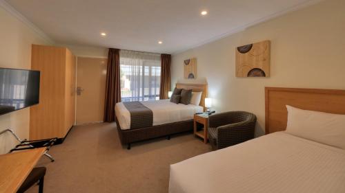 西摩新渡广场汽车旅馆的酒店客房设有两张床和电视。