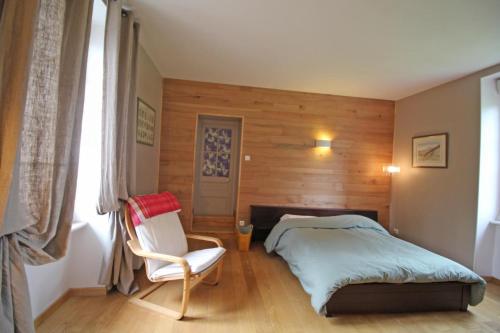 GlandonLe gueraudier的卧室配有床、椅子和窗户。
