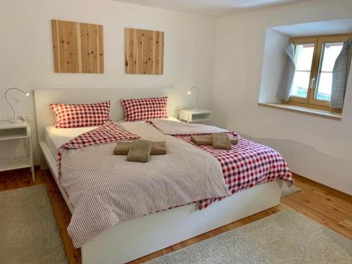 瓜尔达Grosszügige Komfort FEWO - ENGADIN HOLIDAYS的一间卧室配有一张带红白毯子的床