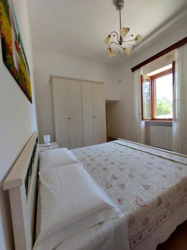 莫诺波利Il Trulletto Del Sognatore的白色的卧室设有一张大床和一个窗户