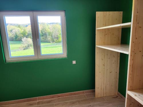 CharchillaGites Jura Sud的一间设有绿色墙壁和窗户的客房