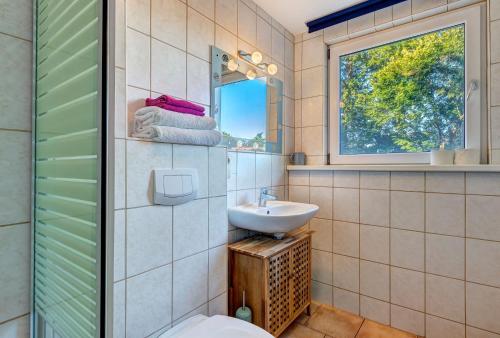 于克里茨Apartment Uferpromenade Steuerboard的一间带水槽和卫生间的浴室以及窗户。