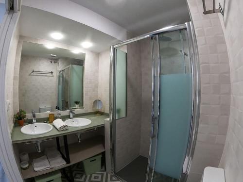 塞维利亚ROCH - Stylish Apartment near Metro的一间带两个盥洗盆和淋浴的浴室