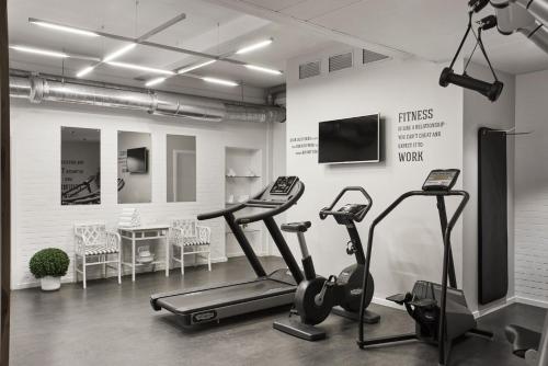 哥本哈根Hypernym Hotel & Suites的健身房设有2辆健身自行车和平面电视