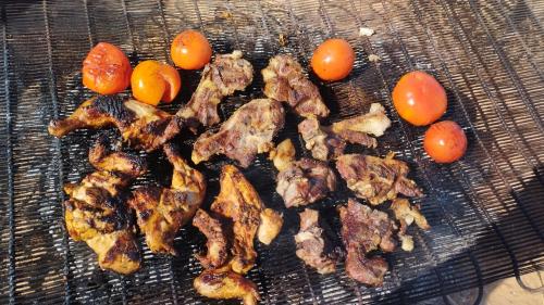 瓦迪拉姆Wadi rum sand Delight camp的烤架上放一些肉和西红柿