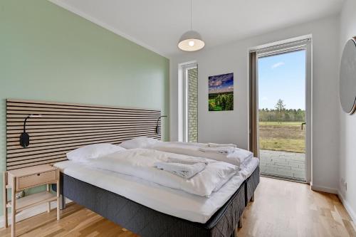 NimtofteLübker Golf Resort的一间卧室设有一张大床和一个大窗户