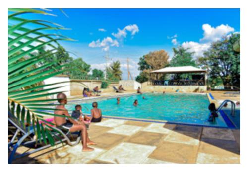BondoRozala Motel的一群人坐在游泳池周围