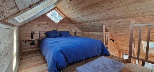 GesvesLes cabanes des Pierreux的小木屋内一间卧室,配有一张床